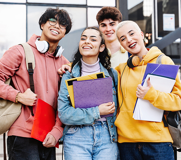 A group of students with backpacks smiling for the photo.